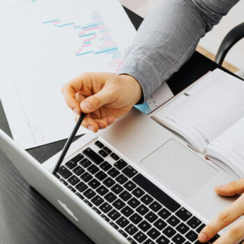 person using laptop holding pen